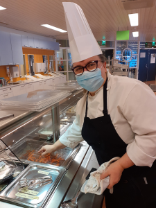 Kuvassa keittiömestari Aija Lyytikäinen asettaa kantta lounasruuan päälle.