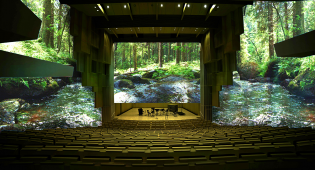 Havainnekuva, miltä konserttisali näyttää, kun seinille on heijastettu suomalaista luontoa. Luontokuva näkyy sekä esiintymislavan takana että sivuilla.