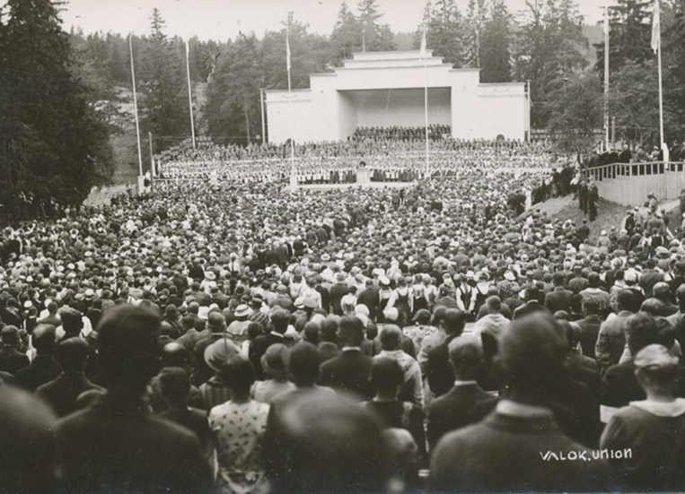 Vanha, mustavalkoinen kuva laulutapahtumasta. Taustalla näkyy esiintymislava, edessä suuri ihmisjoukko.
