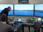 Kaksi merikapteeniopiskelijaa ohjaa laivaa simulaattorissa kohti Suomenlinnan ja Vallisaaren välissä olevaa Kustaanmiekan salmea Helsingissä. Isoista monitoreista näkymä on verrattavissa aluksen tutkien tuottamaan kuvaan konsolitasojen näytöissä.
