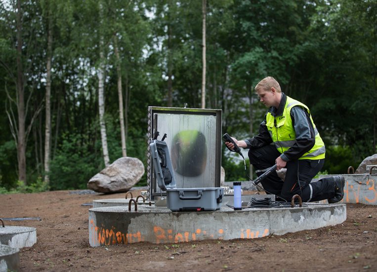 Kuvassa henkilö tekemässä monitorointia Pitkäjärven hulevesien käsittelyn T&K-ympäristössä.