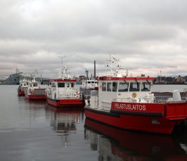 Kuvassa viisi alusta laiturissa, taustalla näkyy Merikeskus Vellamo.