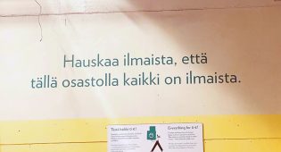 Kuva kierrätyskeskuksen seinästä, jossa teksti: Hauskaa ilmaista, että tällä osastolla kaikki on ilmaista.